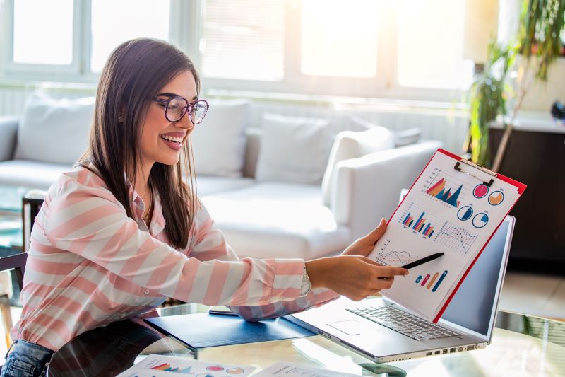 mulher economista explica sobre ciclo econômico mostrando gráficos e informações impressas