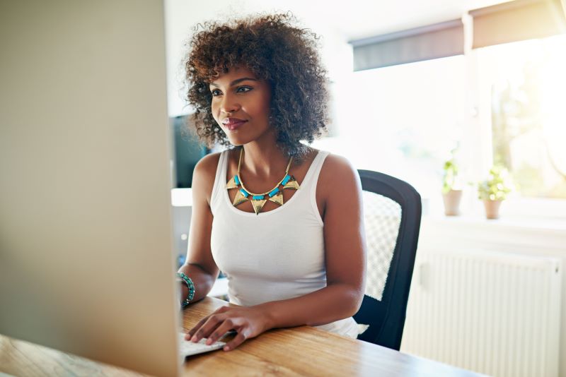 mulher negra trabalhando em escritório em frente ao computador, para ilustrar a gestão de custos para contadores.