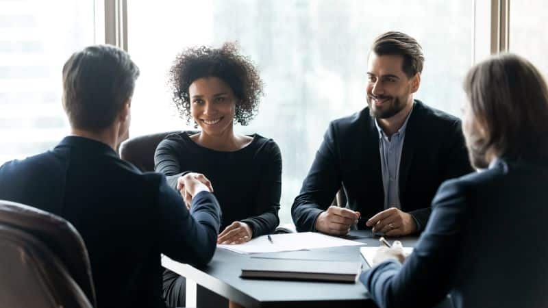 icp o que é: vendedores apertando a mão de cliente e fechando negócio em reunião