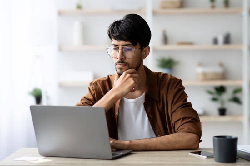 Customer lifetime value: homem pensativo trabalhando no computador.