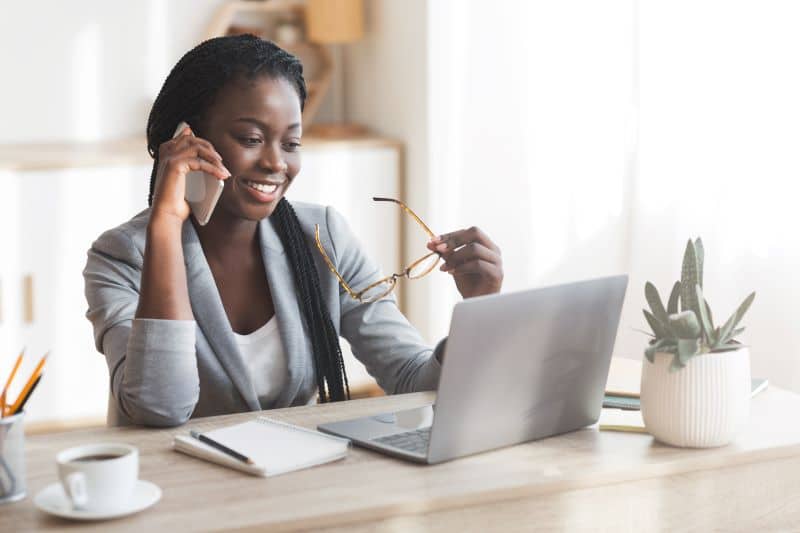 Nota fiscal avulsa: mulher falando ao celular enquanto trabalha no computador.