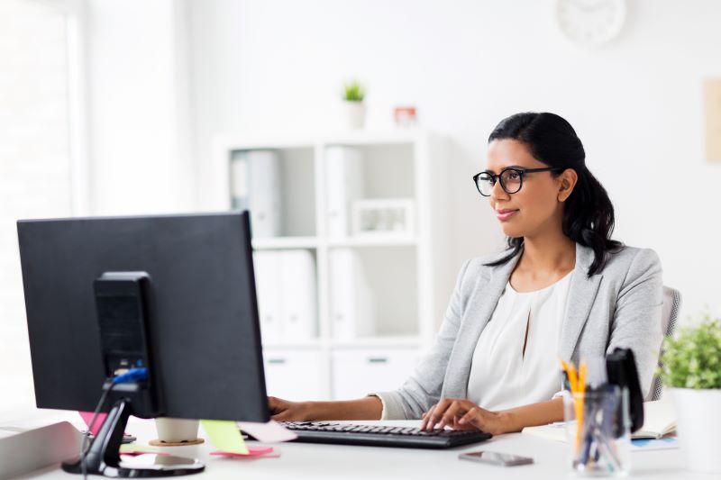 Análise descritiva: mulher trabalhando no computador em escritório.