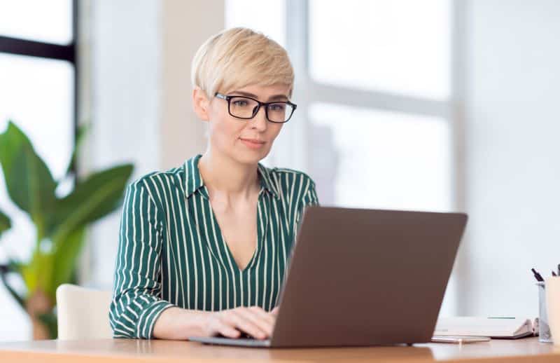 Exemplo de relatório pronto: mulher trabalhando no computador.
