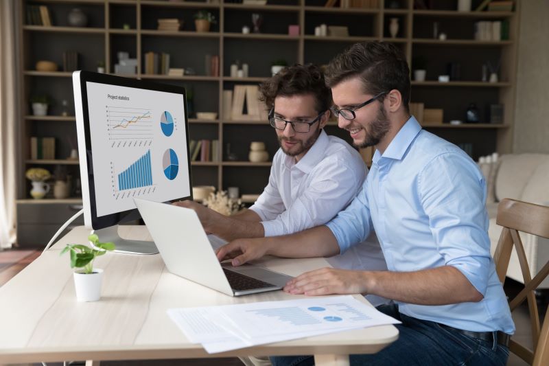 indicadores de rentabilidade​: dois homens analisando gráficos no computador