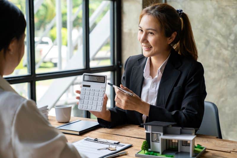 qual o melhor índice para reajuste de contrato​: mulher em escritório mostrando resultado em calculadora para cliente