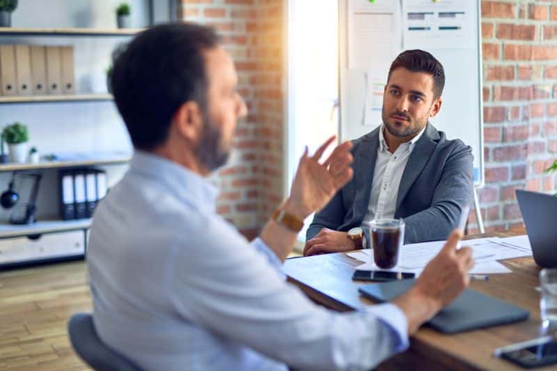 negócio escalável​: homens em escritório discutindo o negócio