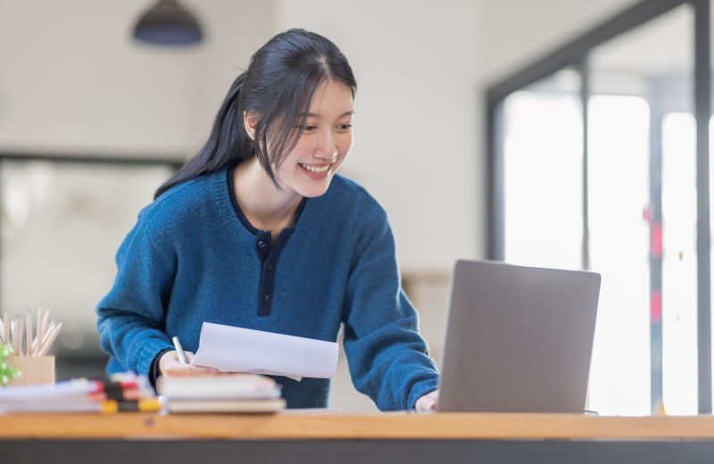 planilha de controle financeiro​: mulher sorridente em escritório usando computador