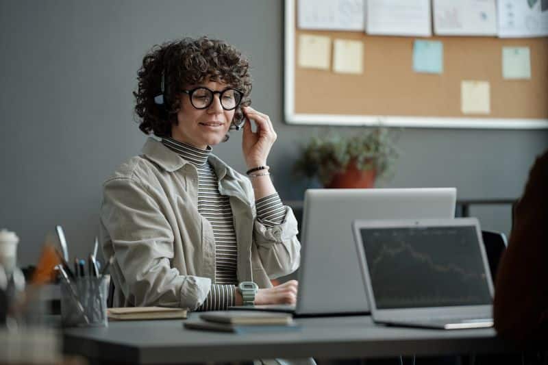 customer health score: mulher em escritório falando com cliente por ligação no computador