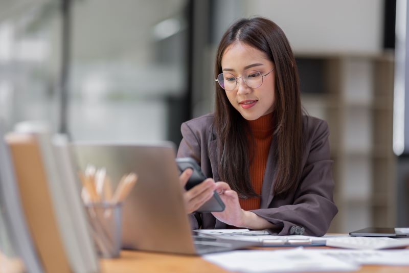 FinOps o que é: mulher usando celular no escritório